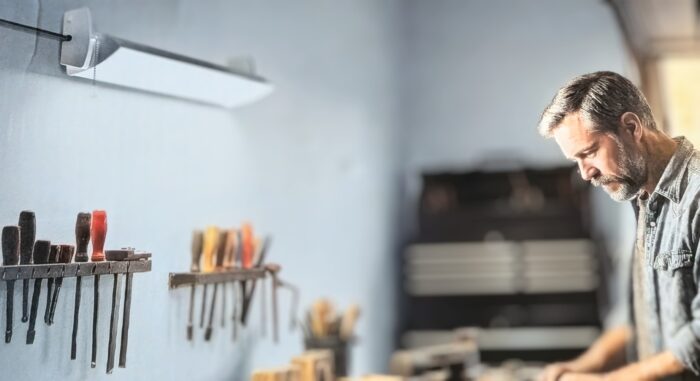 KODA 10,000-lumen adjustable LED shop light illuminating a workshop workbench